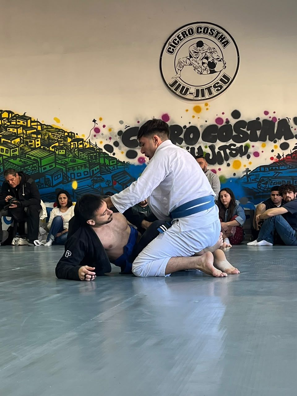 Dos competidores con kimono negro y blanco disputan una posición en el tatami